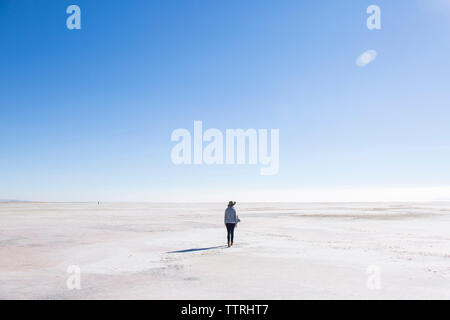 Ansicht der Rückseite Frau wandern in der Great Salt Lake gegen den blauen Himmel während der sonnigen Tag Stockfoto