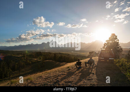 Ansicht der Rückseite des Freunde sitzen auf Feld gegen Sky Stockfoto