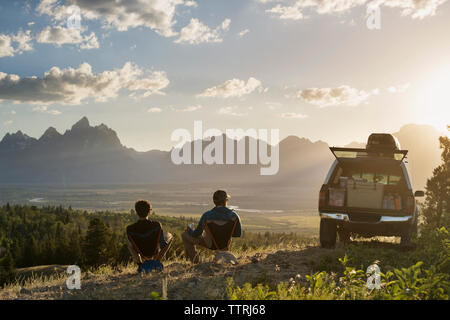 Ansicht der Rückseite des männlichen Wanderer relaxen im Liegestuhl im Feld Stockfoto