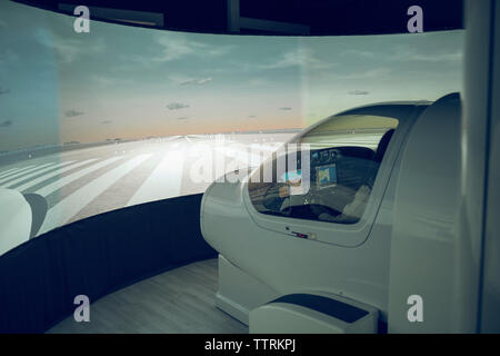 Seitenansicht der männlichen Auszubildenden fliegen Flugsimulator durch die Windschutzscheibe sichtbar Stockfoto