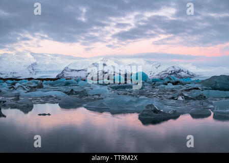 Malerischen Blick auf die Eisberge auf dem See in der Nähe von Bergen im Schnee in Jokulsarlon, Island Stockfoto