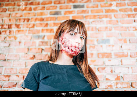 Frau mit ihrem Gesicht mit Terror Wunden gemalt. Stockfoto