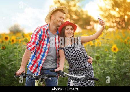 Junges Paar auf Fahrräder, Foto im Feld Stockfoto