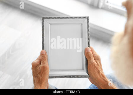 Alte Mann mit Bilderrahmen Stockfoto