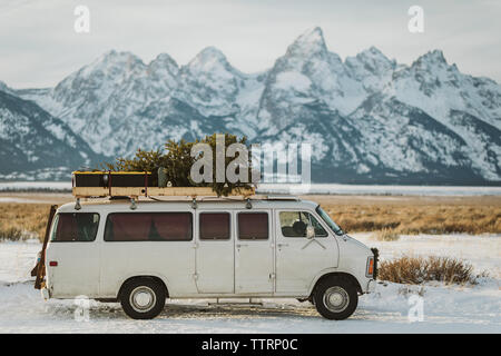 Alte weiße van geparkt am Straßenrand mit Weihnachtsbaum in den Tetons Stockfoto