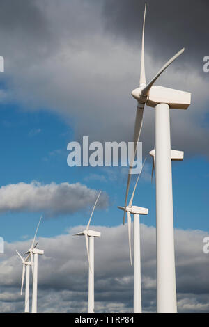 Low Angle View von Windenergieanlagen gegen bewölkter Himmel Stockfoto