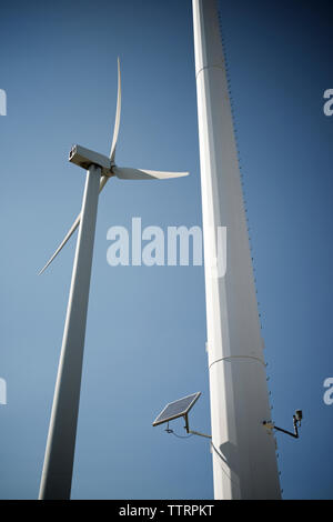 Low Angle View von Solarmodulen auf Mühle gegen den blauen Himmel Stockfoto