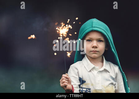 Portrait von Boy holding Wunderkerze im Park Stockfoto