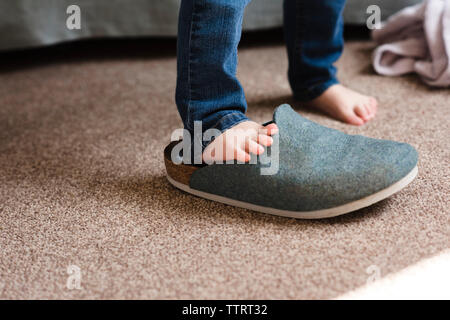 Low-Feld der Mädchen mit grossen Schuh zu Hause Stockfoto