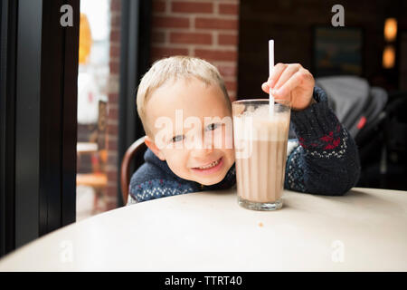 Close-up Portrait von Jungen in Getränk am Tisch im Cafe Stockfoto