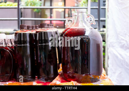 Generische Flaschen der kanadischen Ahornsirup Flüssigkeit (natürliche, essbare Baum sap), draußen sein bei einem Anbieter Tabelle während der Wintersaison verkauft. Stockfoto