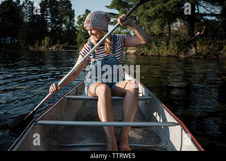 Glückliche Frau Rudern mit dem Boot auf dem See bei Algonquin Provincial Park Stockfoto