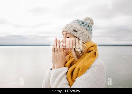 Portrait von blonde Frau wärmen Ihre Hände am Strand im Winter Stockfoto