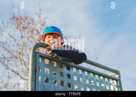 Porträt eines Jungen mit blauen Helm, suchen Kamera im sonnigen Tag Stockfoto