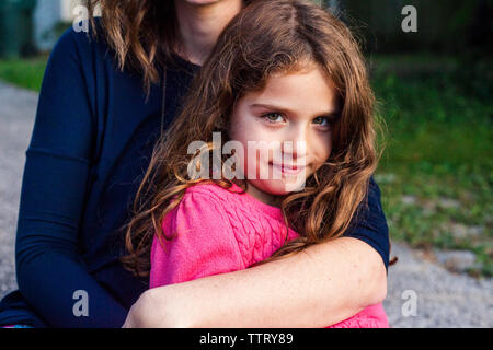 Mittelteil der Mutter die Tochter während der Sitzung in Hof Stockfoto