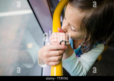 Hohe Betrachtungswinkel von cute girl Blick durch Fenster in Zug Stockfoto