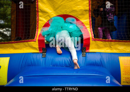 In der unteren Hälfte ein Kind in einem tutu Klettern in einem bouncehouse Stockfoto