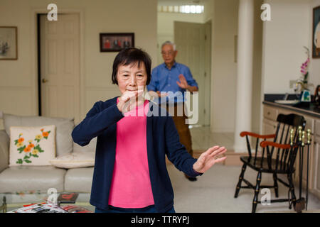 Asiatische älterer Mann und Frau praktizieren Tai-Chi zu Hause Stockfoto