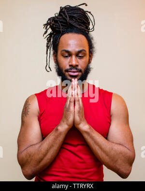 Ein stattlicher Mann mit langen Haaren steht in Yoga Gebet darstellen Stockfoto