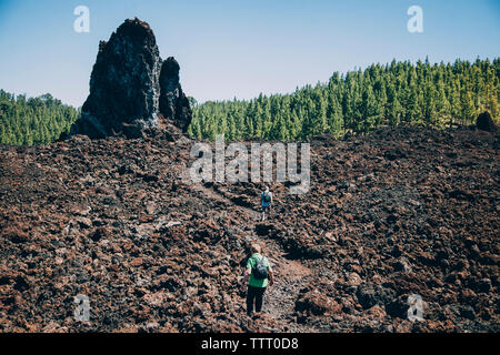 Zwei Menschen laufen durch die vulkanische Landschaft, auf einem beeindruckenden Weg Stockfoto