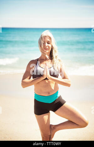 Bestimmt reife frau yoga in die baumhaltung in Delray Beach Stockfoto