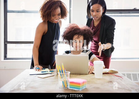 Geschäftsfrauen, die im kreativen Büro Laptop verwenden Stockfoto