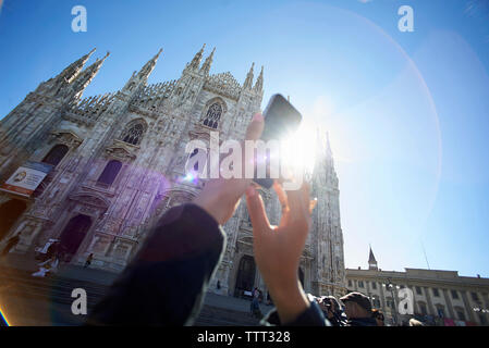 7/8 Bild der Frau fotografieren Duomo di Milano gegen den klaren blauen Himmel Stockfoto