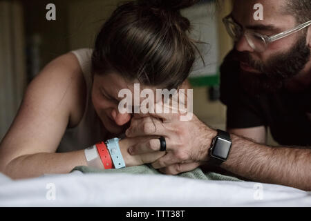 Close-up des Menschen tröstlich schmerzhafte schwangere Frau am Krankenbett Stockfoto