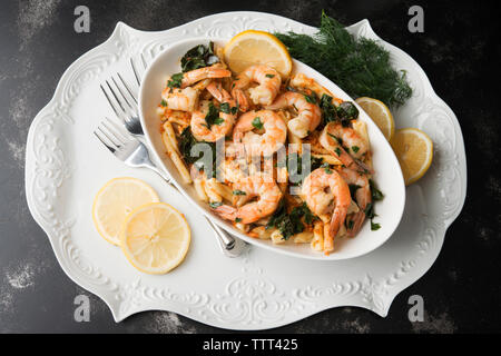 Hohe Betrachtungswinkel von Garnelen auf Pasta, garniert mit Dill und Zitronenscheiben in der Platte Stockfoto