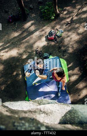 Ansicht von oben von Paar Vorbereitung zum Klettern im Wald Stockfoto