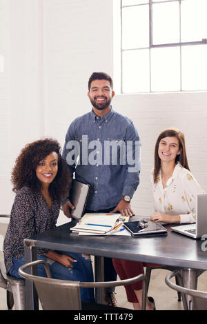 Portrait von zuversichtlich Geschäftsleute haben am Tisch im Büro Stockfoto