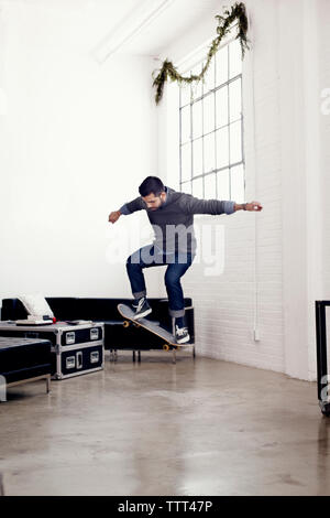 Geschäftsmann Skateboarding im Kreativbüro Stockfoto