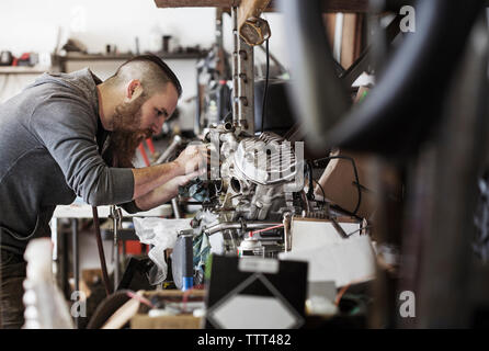 Ernsthafte Mechaniker arbeiten am Motorrad Motor im Auto Repair Shop Stockfoto