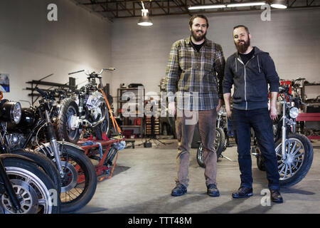 Zuversichtlich Mechanik stehend von Motorrädern in der Werkstatt Stockfoto