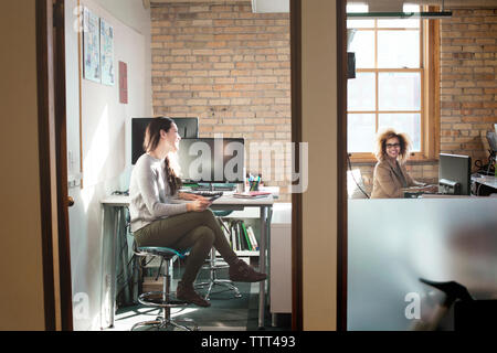 Happy Unternehmerinnen im Gespräch in kreative Büro Stockfoto