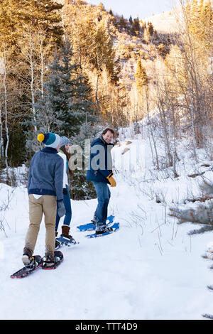 Happy Family Schneeschuhwandern auf schneebedeckten Feld Stockfoto