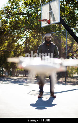 Mann fliegende Drohne im Basketball Court Stockfoto