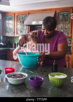 Mutter, Tochter mix Zutaten für Cookies Stockfoto