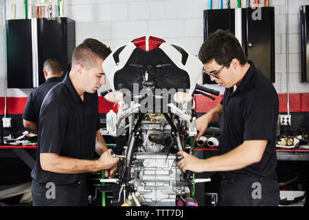 Arbeiter, die Motorräder in der Fabrik untersuchen Stockfoto