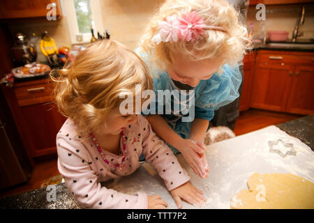 Hohe Betrachtungswinkel von Happy Schwestern, die Cookies in der Küche zu Hause. Stockfoto