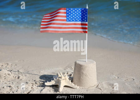 Sand Castle mit amerikanischer Flagge am Strand Stockfoto