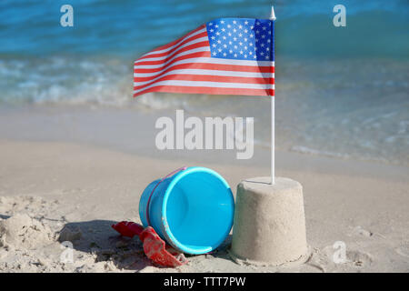 Sand Castle mit amerikanischer Flagge am Strand Stockfoto