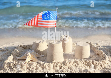 Sand Castle mit amerikanischer Flagge am Strand Stockfoto