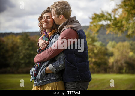 Paar umarmen und küssen schließen oben mit Wind im Feld Stockfoto
