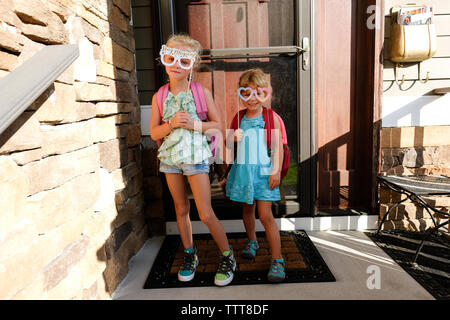 Zwei Mädchen halten dumm Papier Brille auf der Veranda Stockfoto