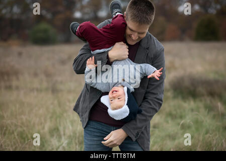 Zugeschnittenes Bild des Vaters holding Sohn Hand am Bauernhof Stockfoto