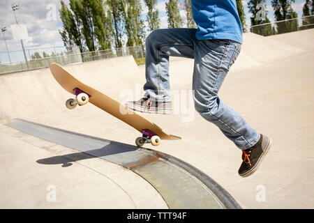 Niedrige Abschnitt der Boy skateboarding auf der Rampe Stockfoto