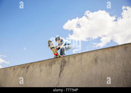 Low Angle View der Boy, Skateboard Rampe gegen den blauen Himmel Stockfoto