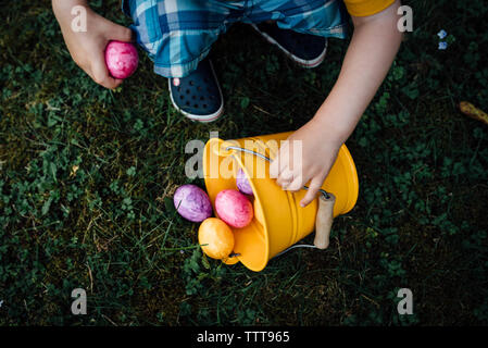 Little Boy suchen Ostereier im Frühjahr auf einer Ostereiersuche Stockfoto