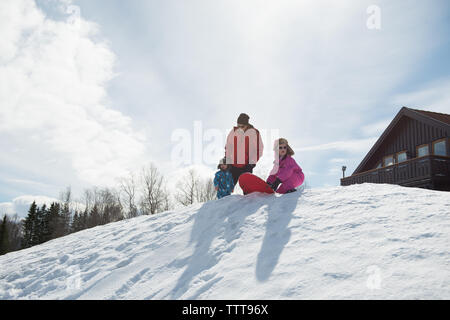 Vater Kinder im Winter Wonderland an einem sonnigen Tag auf Snow Mountain Stockfoto